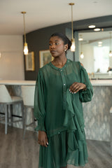 Woman in a green dress standing in a modern interior setting